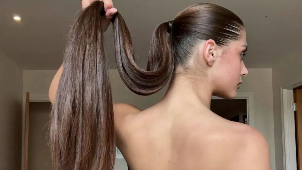 Mujer con coleta alta muy tirante que ejerce tensión constante sobre las sienes y la línea de nacimiento del pelo